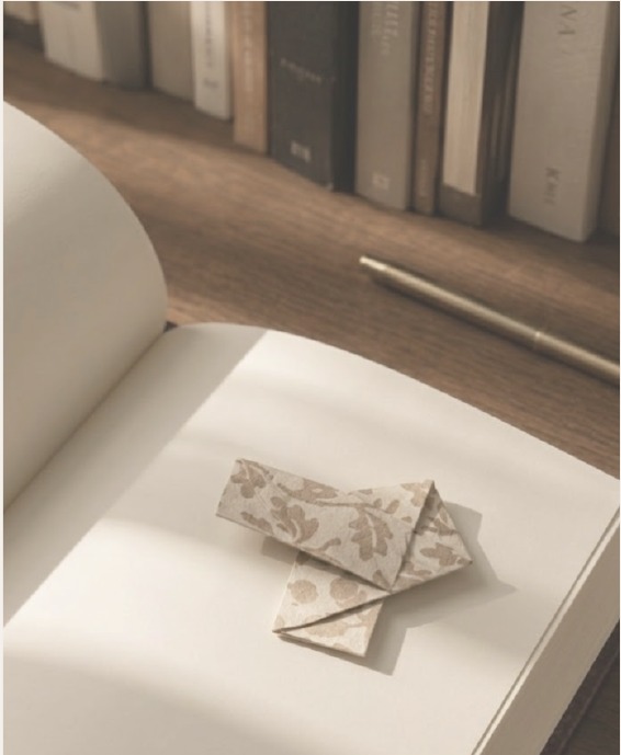 Desk with an open notebook and folded paper detail